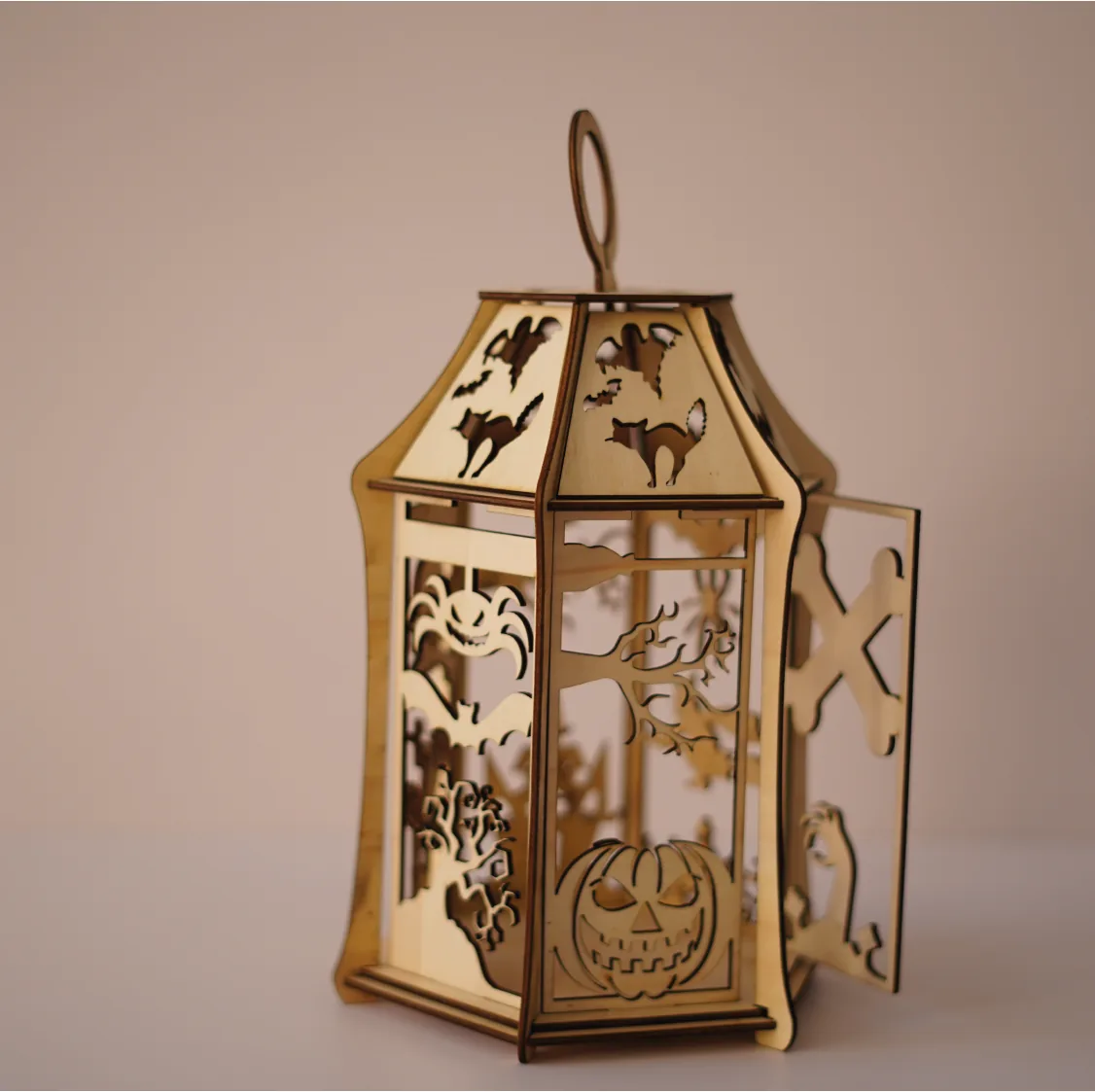 The lantern with its door panel open, showing a jack-o-lantern cutout inside